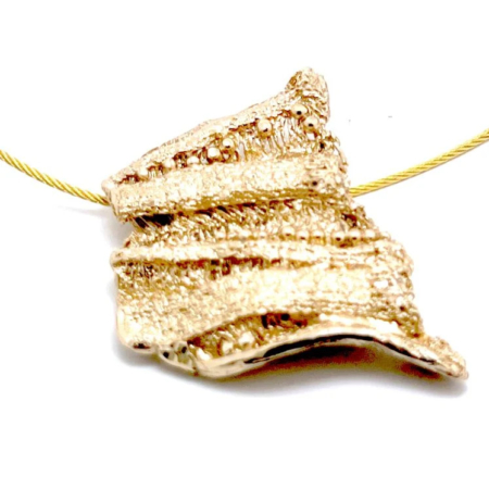 Ένα εντυπωσιακό κολιέ από ορείχαλκο, που φέρει την ανάγλυφη υφή και τις φυσικές γραμμές ενός κορμού δέντρου. Με μοναδικό design και χρωματικές πατίνες, μεταφέρει τη δύναμη και την αρμονία της φύσης σε ένα εκφραστικό κόσμημα.